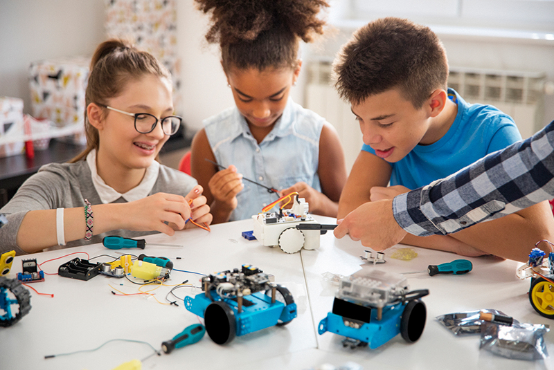 Kinderen knutselen samen aan een robot in het klaslokaal