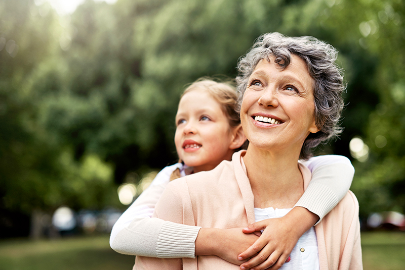 Een mama neemt haar dochtertje op haar schouders