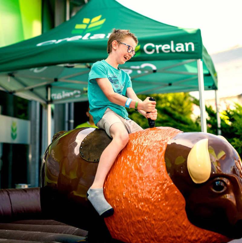 Picture of a boy on toy mechanical bull on a Crelan event