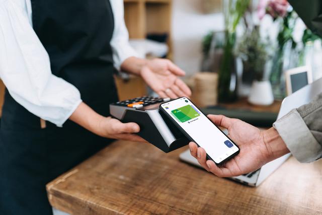 Een klant betaalt met zijn smartphone via Google Pay in de winkel