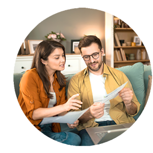 Image ronde d'un jeune couple vérifiant leurs factures sur le canapé