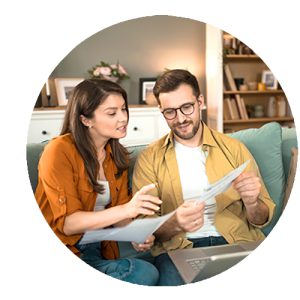 Image ronde d'un jeune couple vérifiant leurs factures sur le canapé