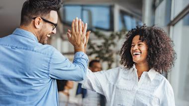 Een gelukkige vrouw geeft een high-five aan een collega