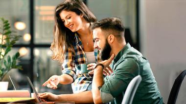 Un couple regarde ses dépenses sur un ordinateur portable