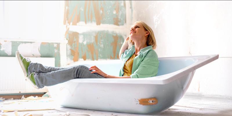 Een vrouw middenin de renovatiewerken van haar badkamer
