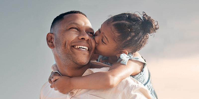 Kindje op de rug van haar vader geeft hem een zoen