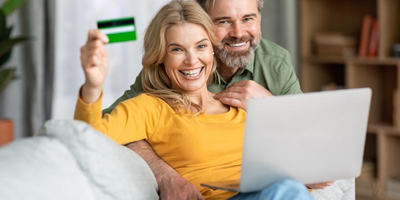 Blije vrouw toont haar Crelan-kaart aan partner