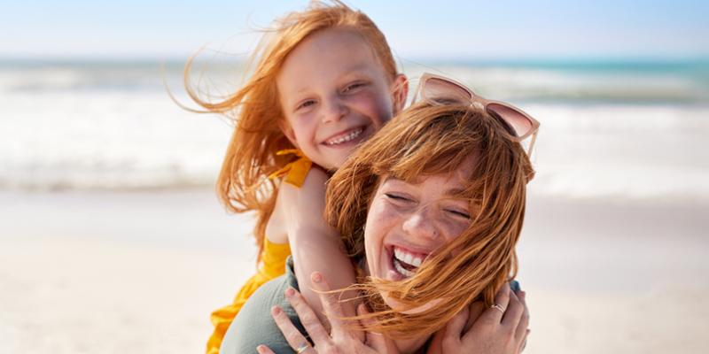 Mama geniet met haar dochter op het strand