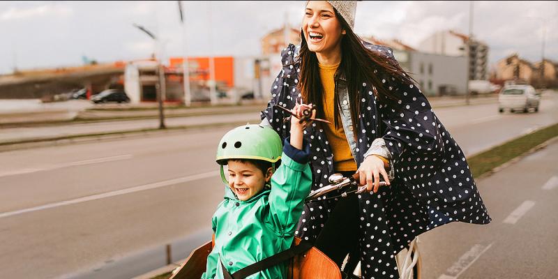 Jeune femme sur un vélo cargo avec sa fille devant