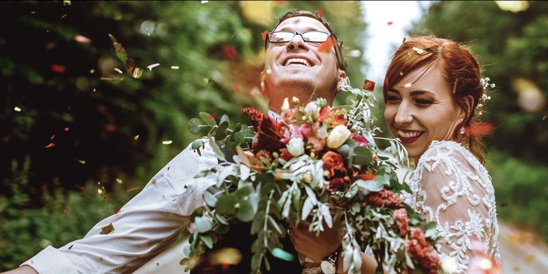 Un jeune couple nouvellement marié avec un bouquet de mariée composé de belles fleurs