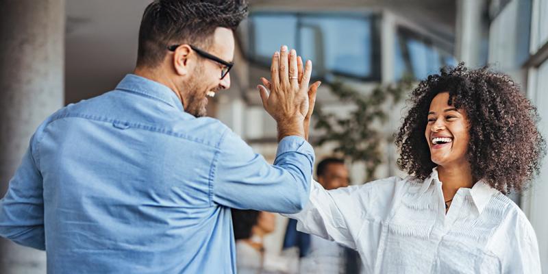 Une femme heureuse donne un high-five à un collègue