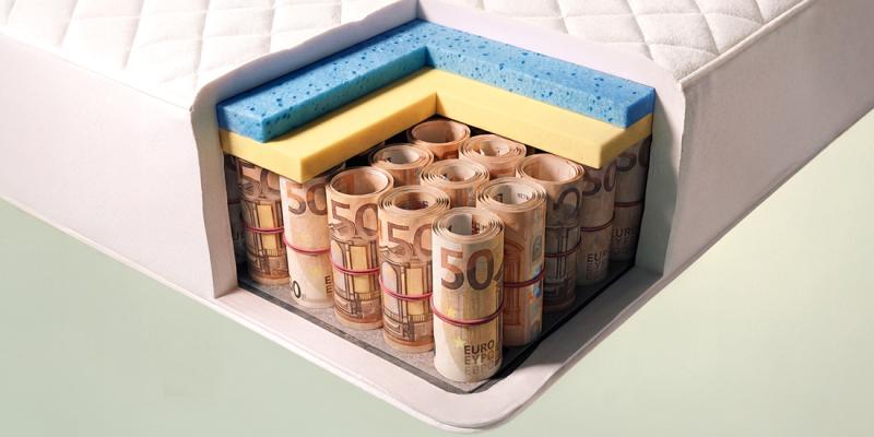 Rolletjes met bankbiljetten zitten in een matras