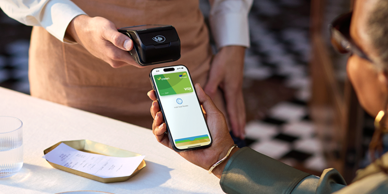 Een vrouw op terras betaalt haar rekening contactloos met Apple Pay