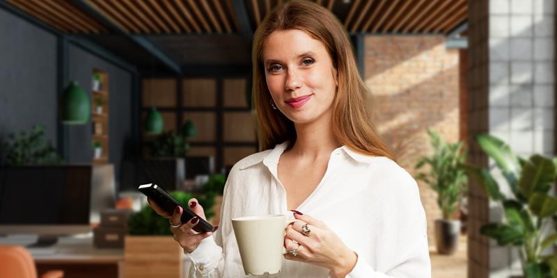 Une jeune femme savoure son café au bureau