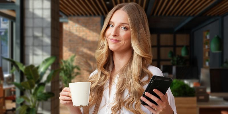 Een jongedame geniet van haar koffie op kantoor