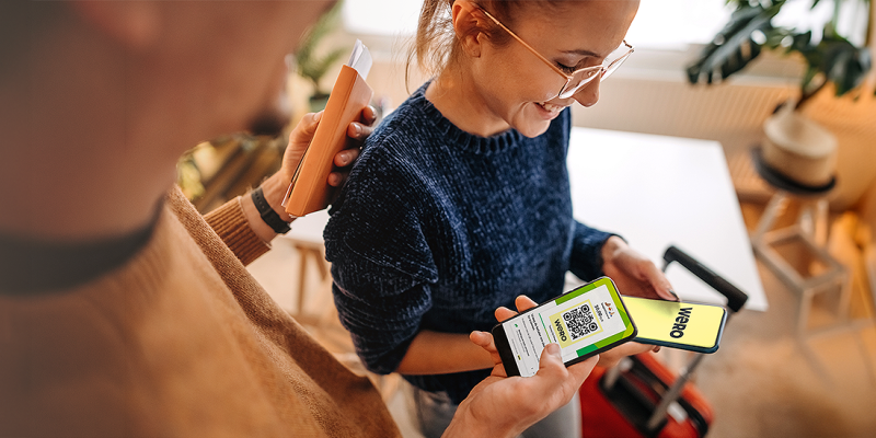 Twee tevreden personen betalen contactloos via hun smartphone met Wero