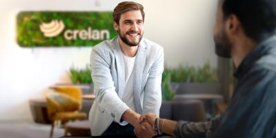 Een Crelan-agent begroet vriendelijk een nieuwe klant op zijn kantoor