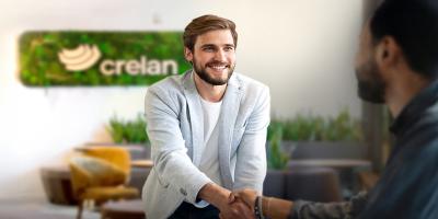 Een Crelan-agent begroet vriendelijk een nieuwe klant op zijn kantoor