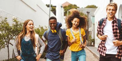 Quatre jeunes gens marchent joyeusement dans la rue