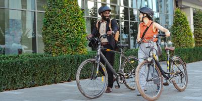 2 jonge mensen lachend in gesprek met hun fiets in de hand