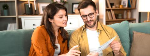 Un couple assis dans un fauteuil regarde une offre 