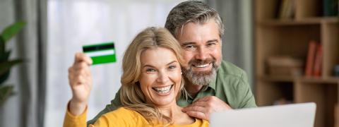 Blije vrouw toont haar Crelan-kaart aan partner