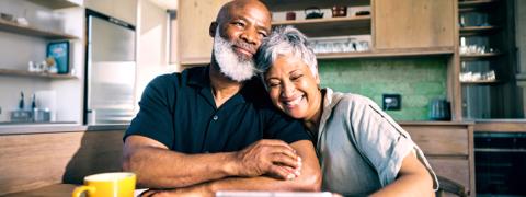 Gepensioneerd koppel kijkt lachend samen op een tablet