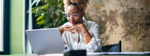 Jonge vrouw bekijkt haar beleggingen op een laptop