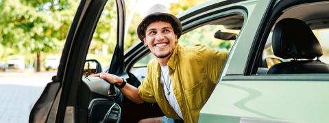 Jongeman met hoed stapt uit wagen