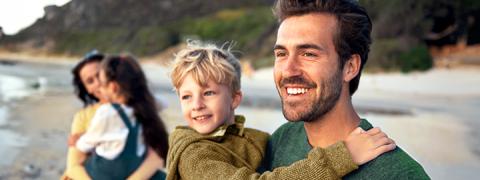 Jong gezin met hun 2 kinderen op het strand