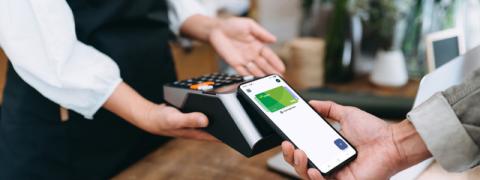 Een klant betaalt met zijn smartphone via Google Pay in de winkel