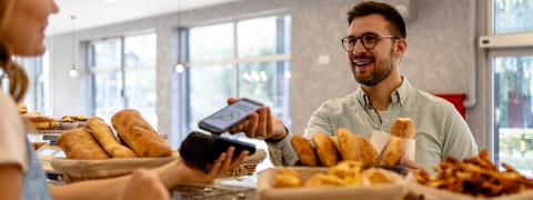 Un jeune homme paie sans contact avec son smartphone