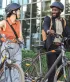 2 jonge mensen lachend in gesprek met hun fiets in de hand