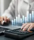 Une personne utilise une calculatrice et consulte des graphiques