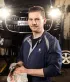 Een jonge garagist werkt aan het onderhoud van een wagen