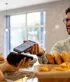 Een tevreden jongeman betaalt contactloos bij de bakker