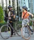 2 jonge mensen lachend in gesprek met hun fiets in de hand