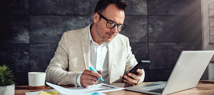 Zakenman becijfert zijn belastingen aan zijn bureau