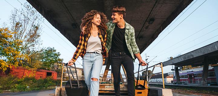 Jong koppeltje lachend op het treinperron