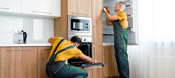 2 werkmannen installeren de nieuwe keuken