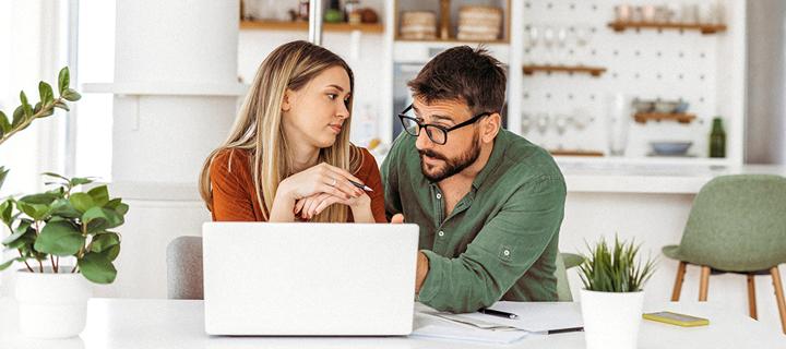 Koppel bekijkt hun financiële mogelijkheden aan de laptop