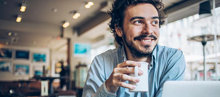 Een jonge man genietend in een koffiebar
