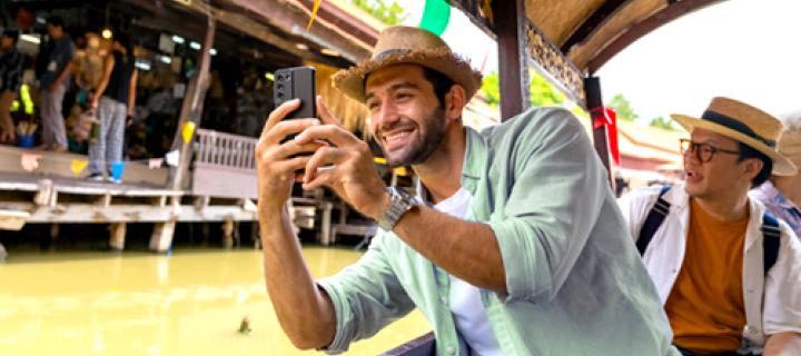 2 vrienden met zomerhoedje trekken selfies aan het water