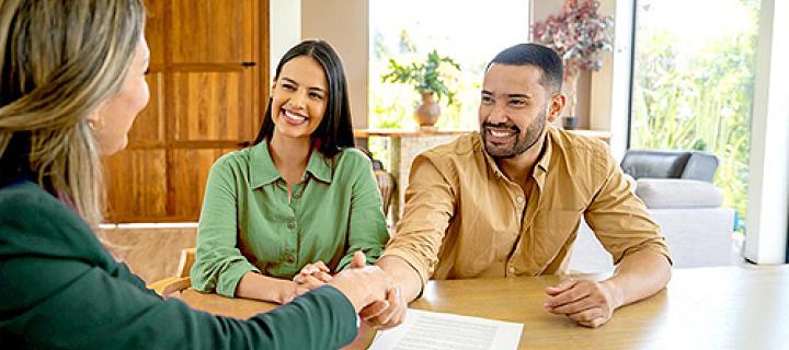 Jong koppel wordt gefeliciteerd door hun notaris