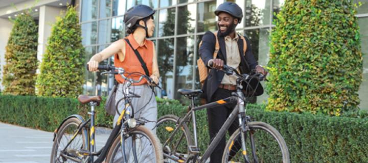 2 jonge mensen lachend in gesprek met hun fiets in de hand