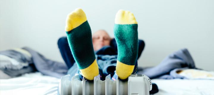 Une personne est allongée détendue, les pieds sur le radiateur