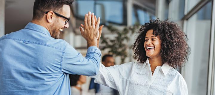 Een gelukkige vrouw geeft een high-five aan een collega