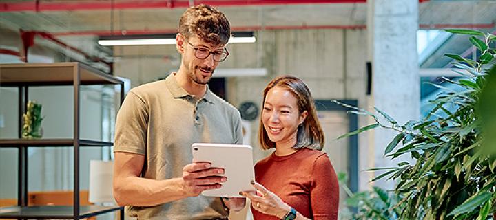 Een jong zakenkoppel bekijkt hun zakencijfers op tablet