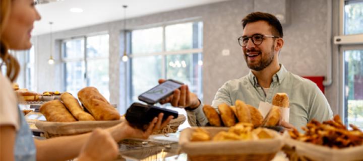 Un jeune homme satisfait paie sans contact à la boulangerie