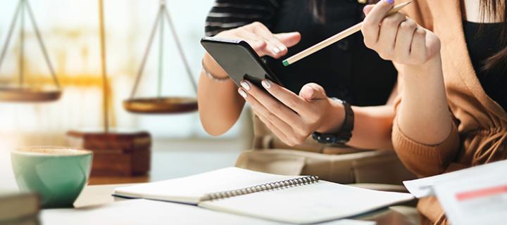 Een jong koppel kijkt hun berekeningen na op een smartphone